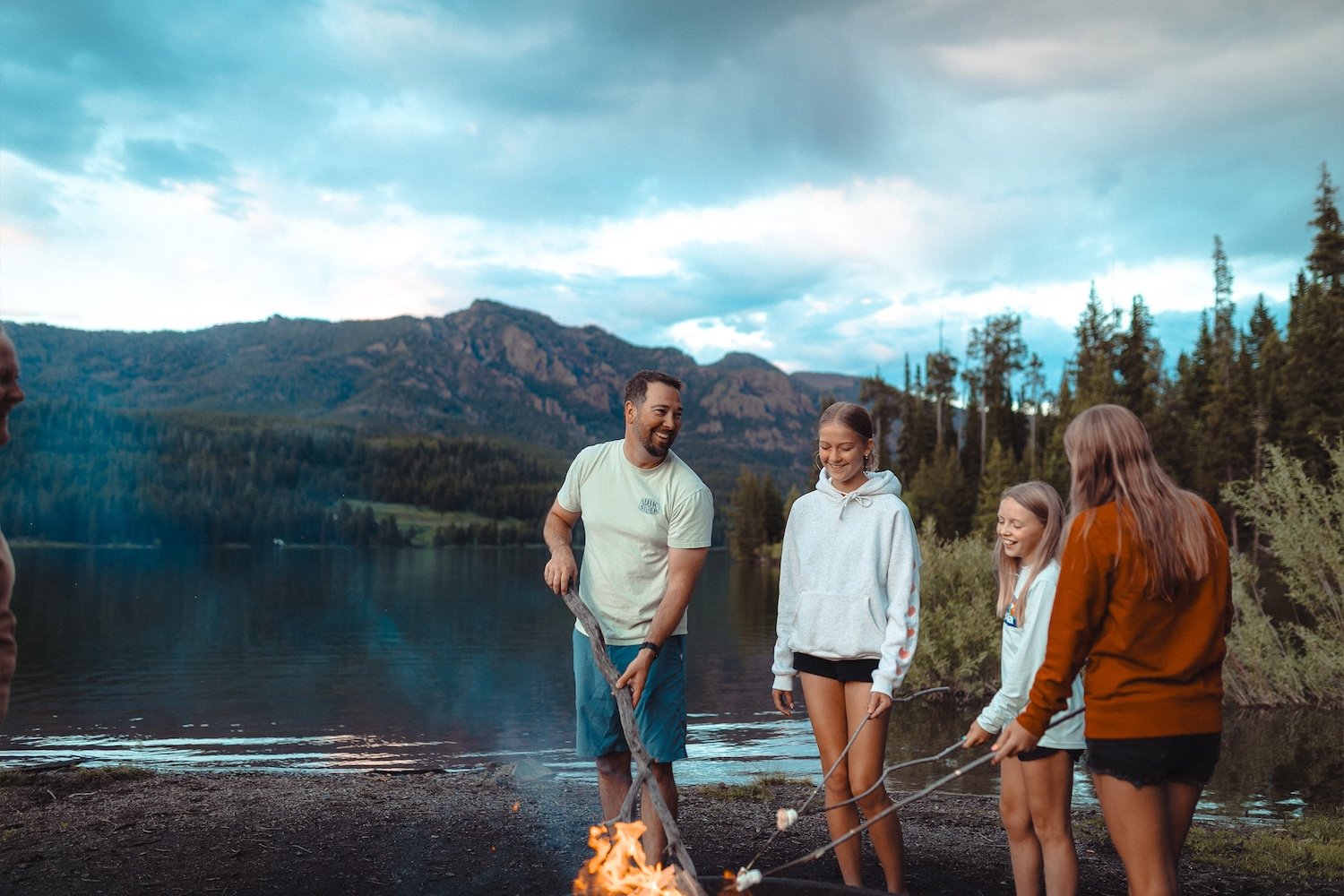 Four people roasting marshmallows at a campfire in Hyalite Canyon.
