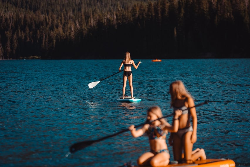 Three people stand up paddle boarding on Hyalite Reservoir