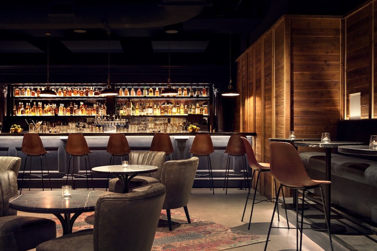 The interior of Tune Up Bar in Bozeman has multiple tables and chairs and a bar