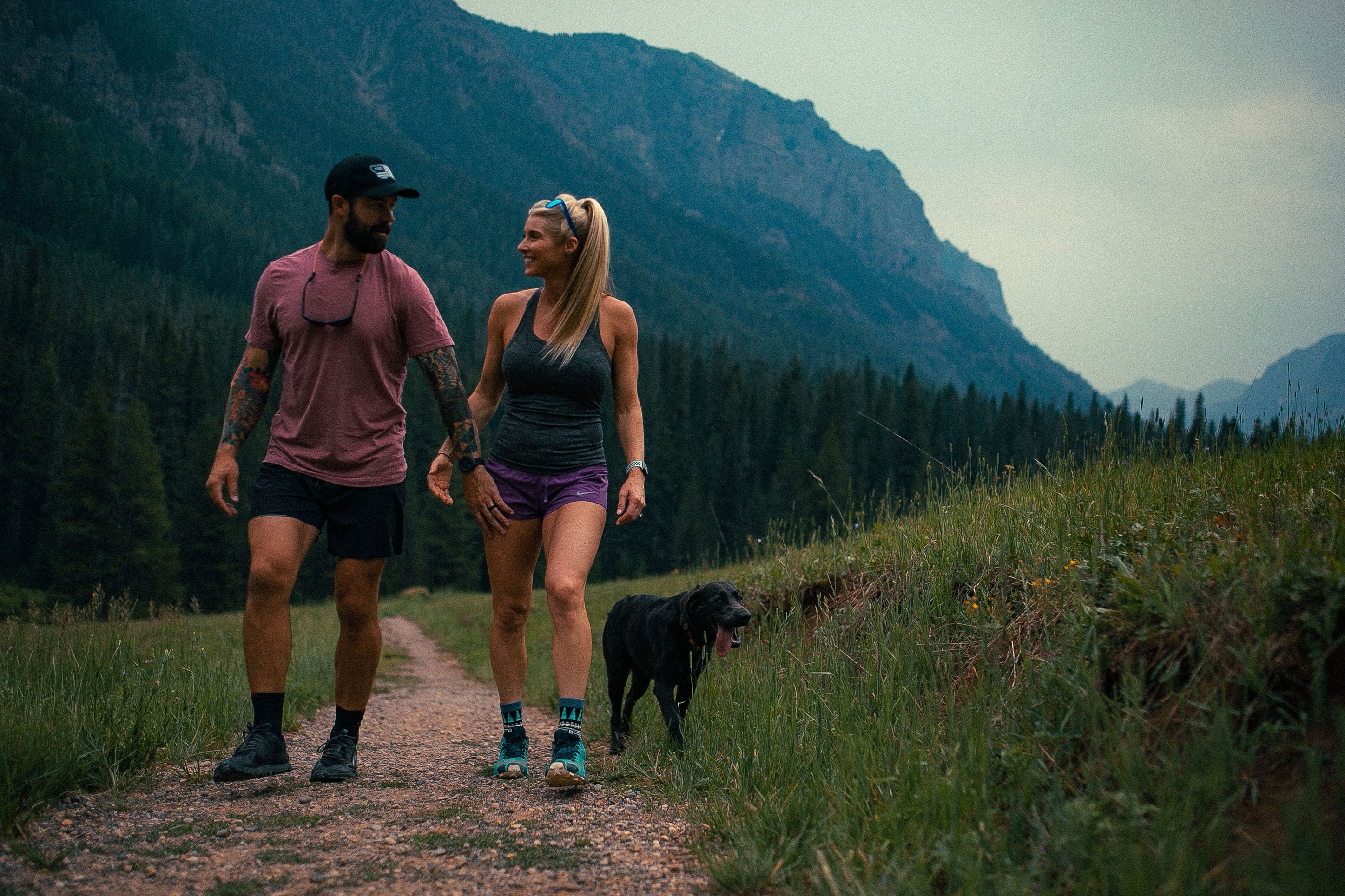 photo of a couple hiking with their dog 