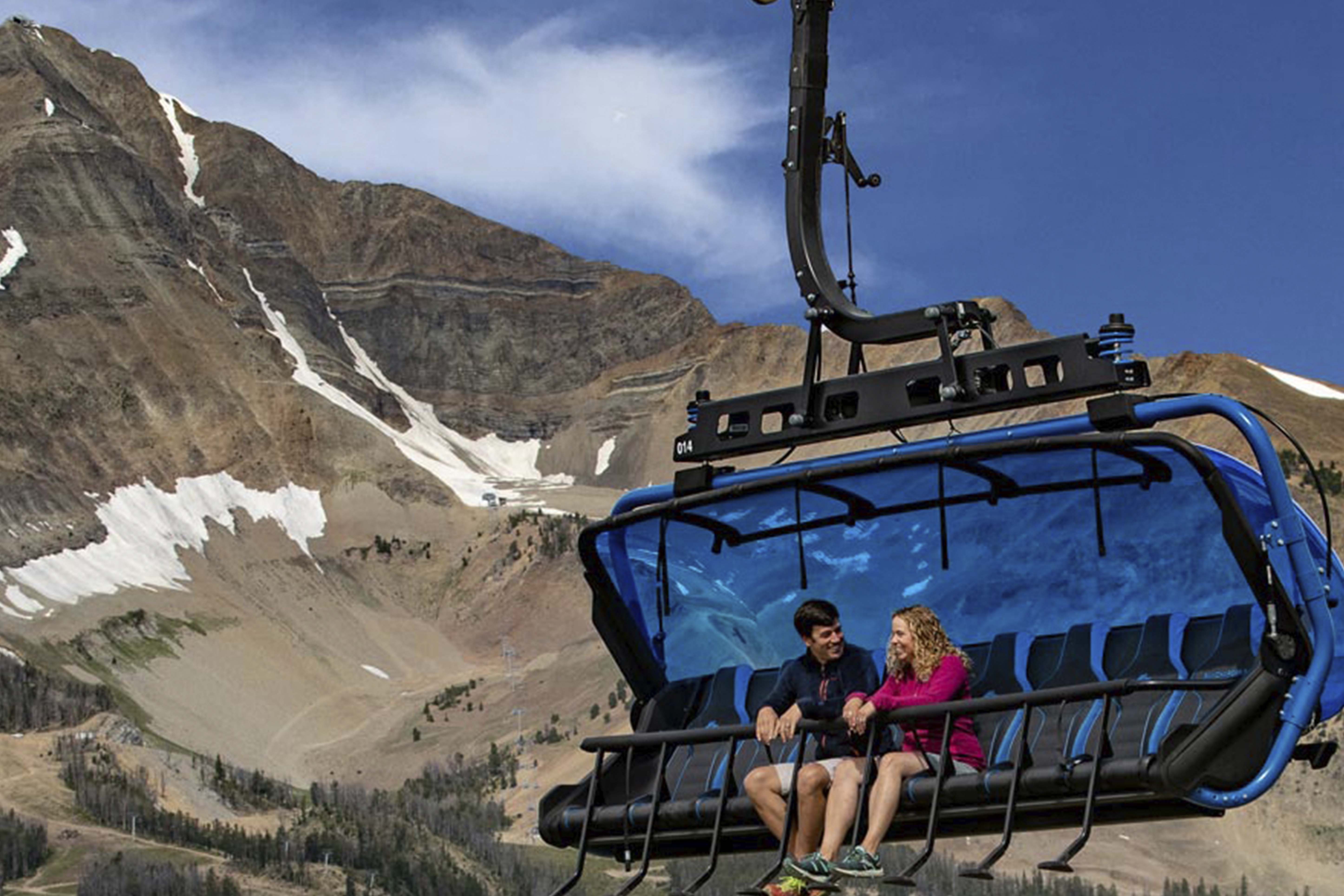 two people on the loan peak sky lift at big sky in the summer