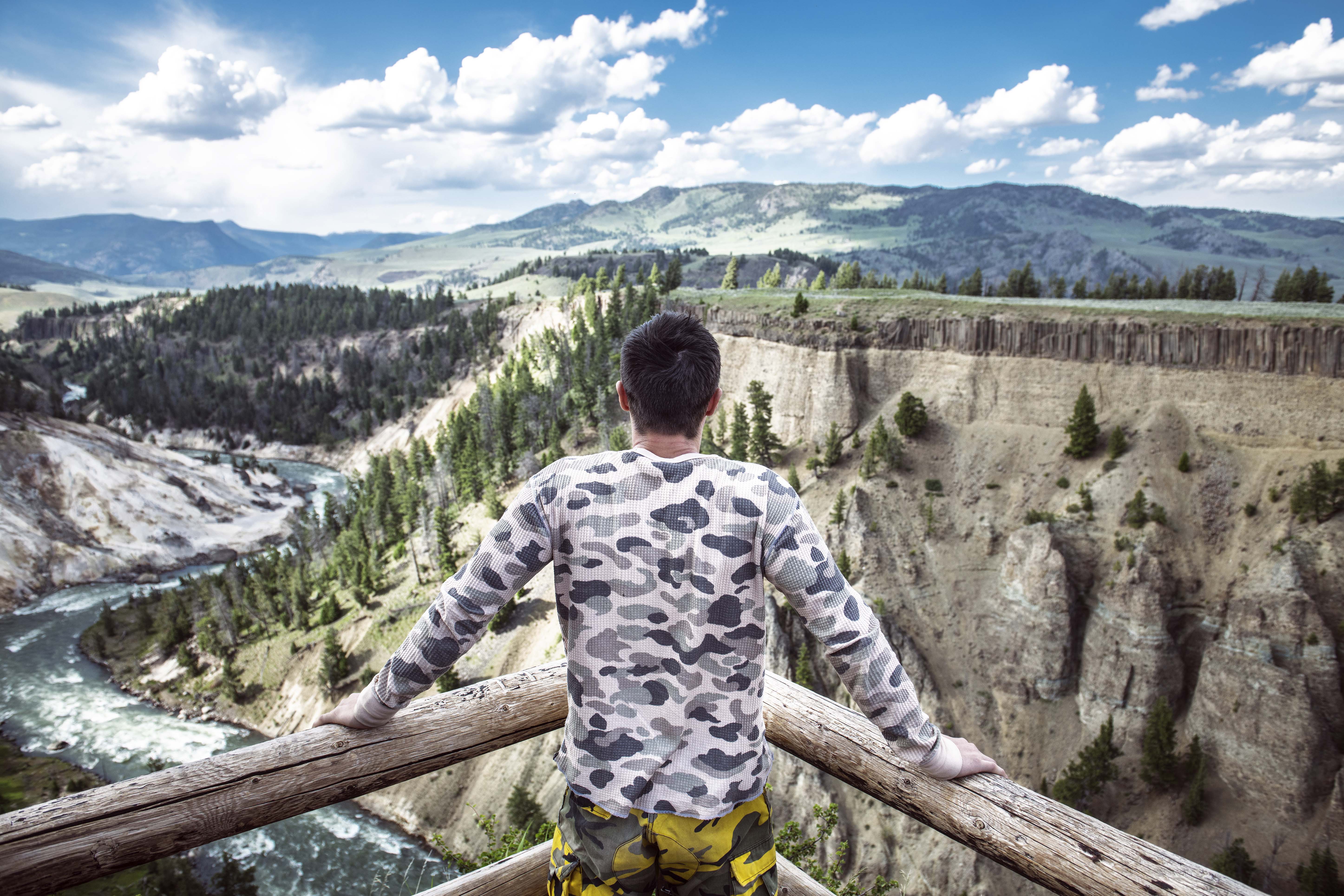 man overlooking the grand canyon of the yellowstone