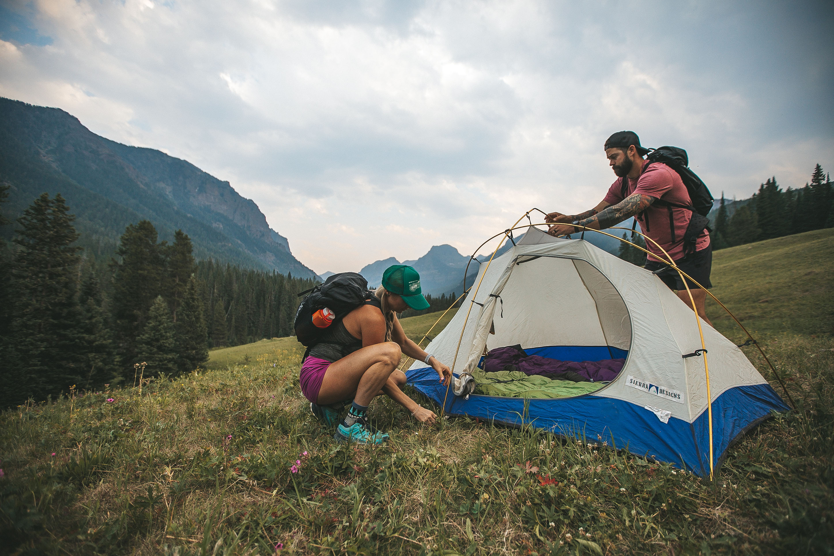 Couple setting up a tent while backpacking