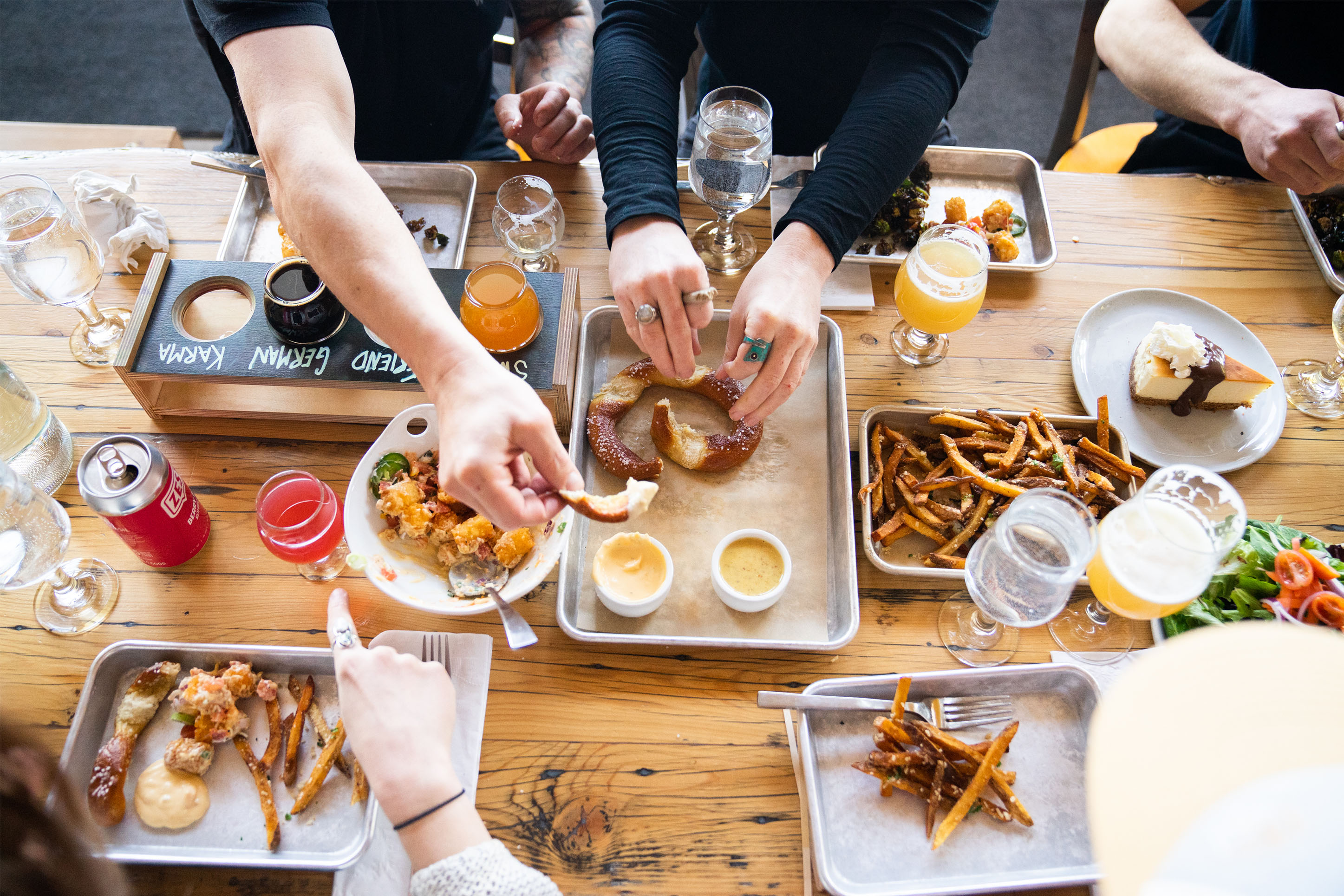 photo of a table full of food at Mountains Walking with hands sampling from the plates