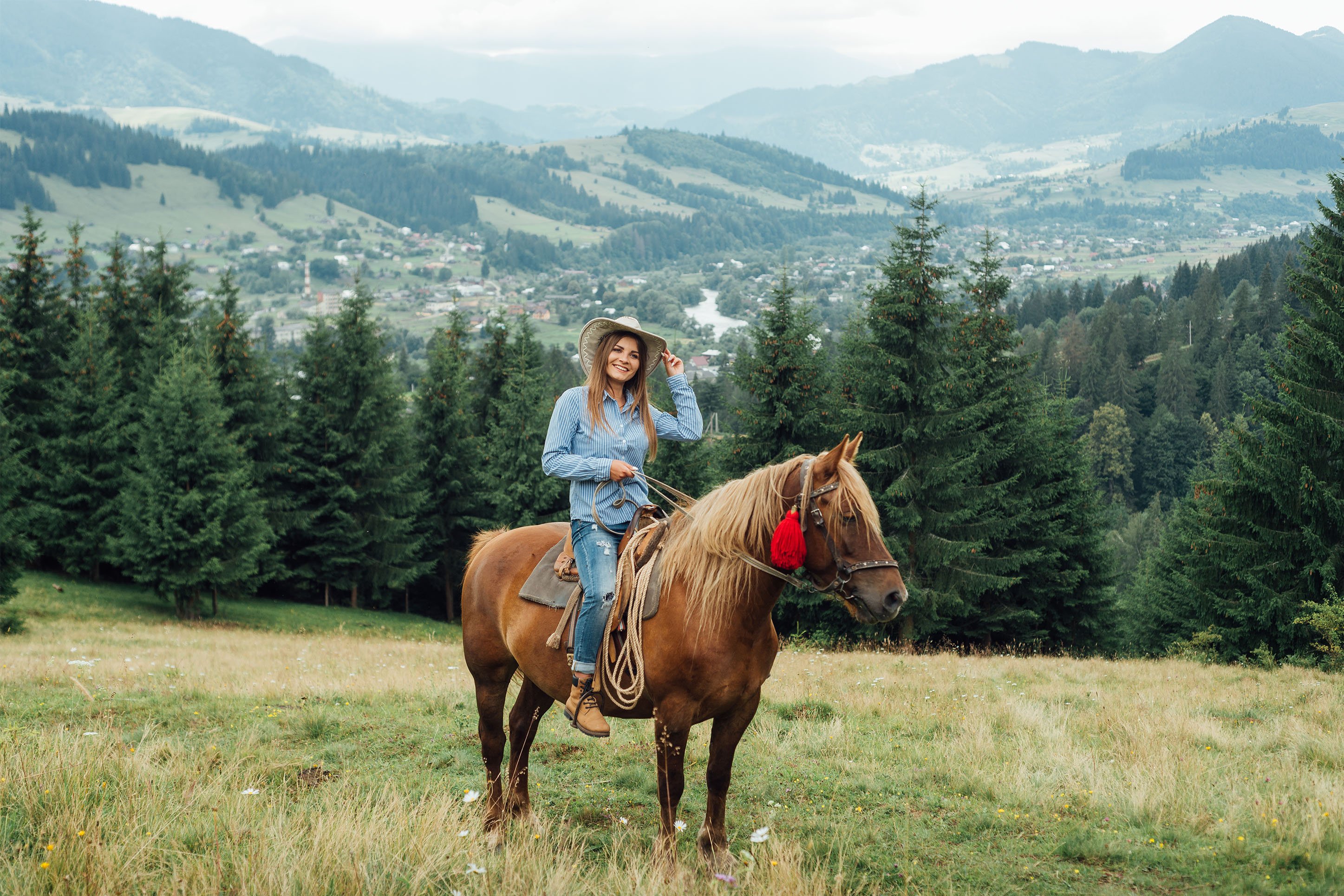Woman on horseback with mountainous terrain behind her