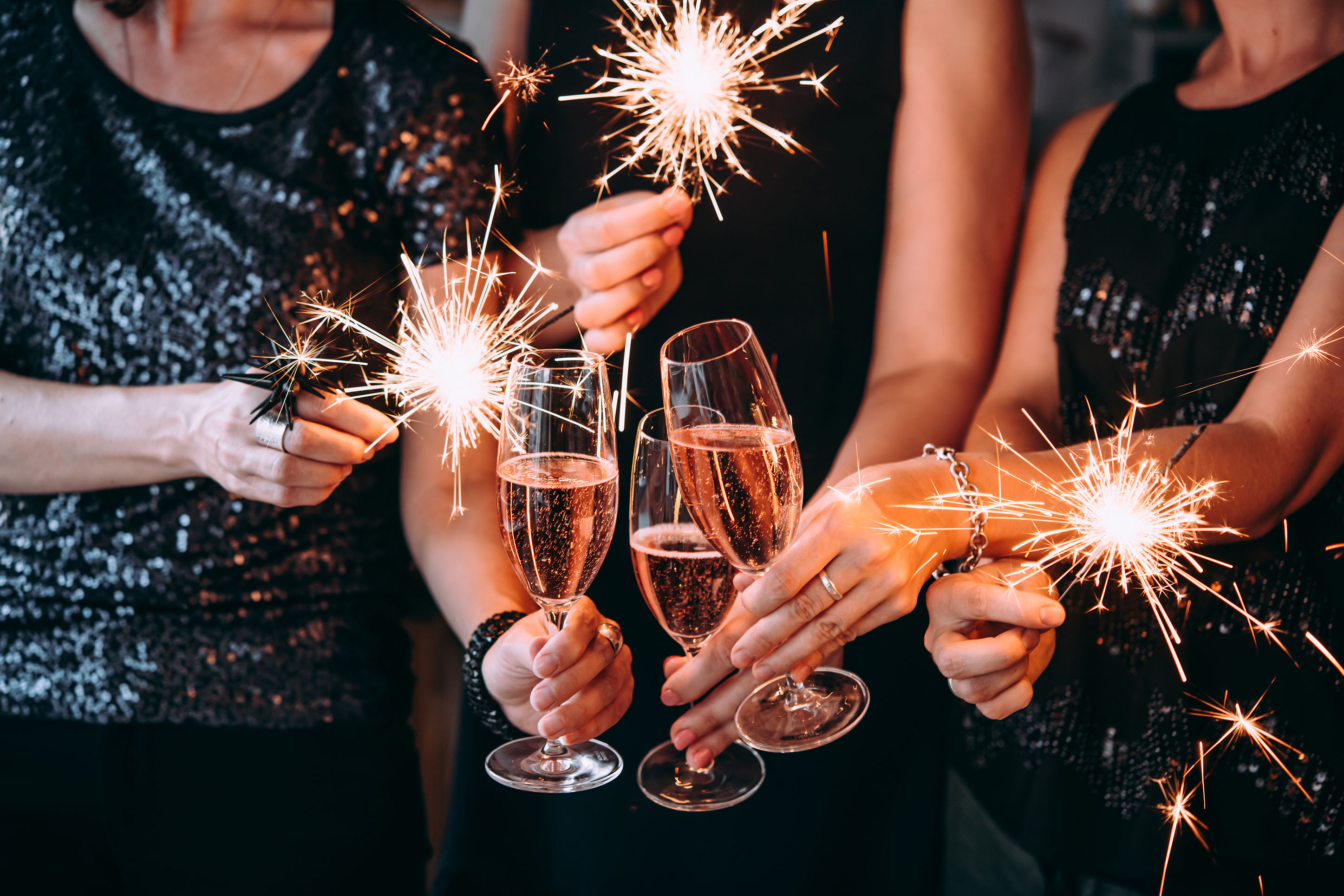 People celebrating with champagne and sparklers. 