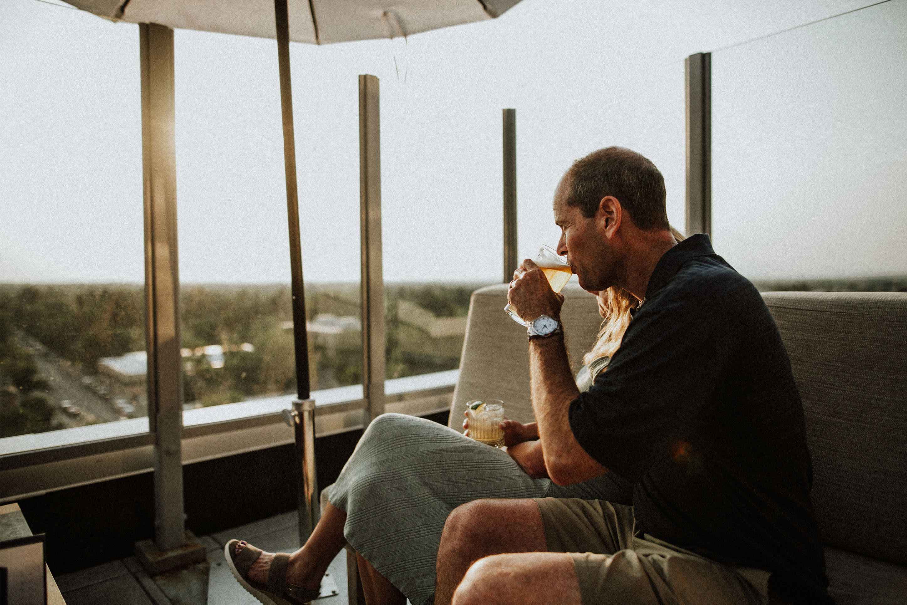 Photo of a couple enjoying cocktails on the rooftop of the Sky Shed bar