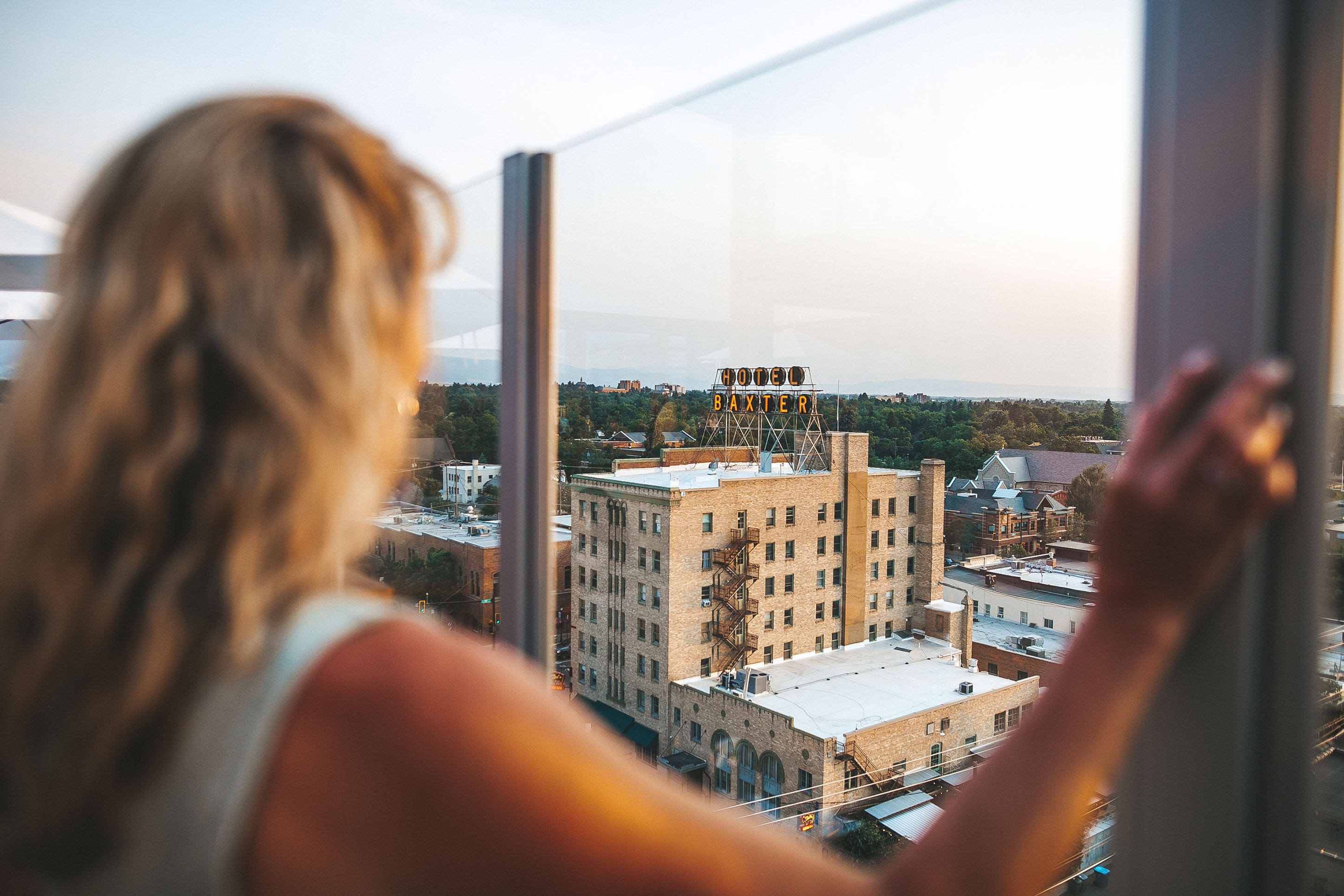 photo over shoulder of a woman looking out over downtown Bozeman