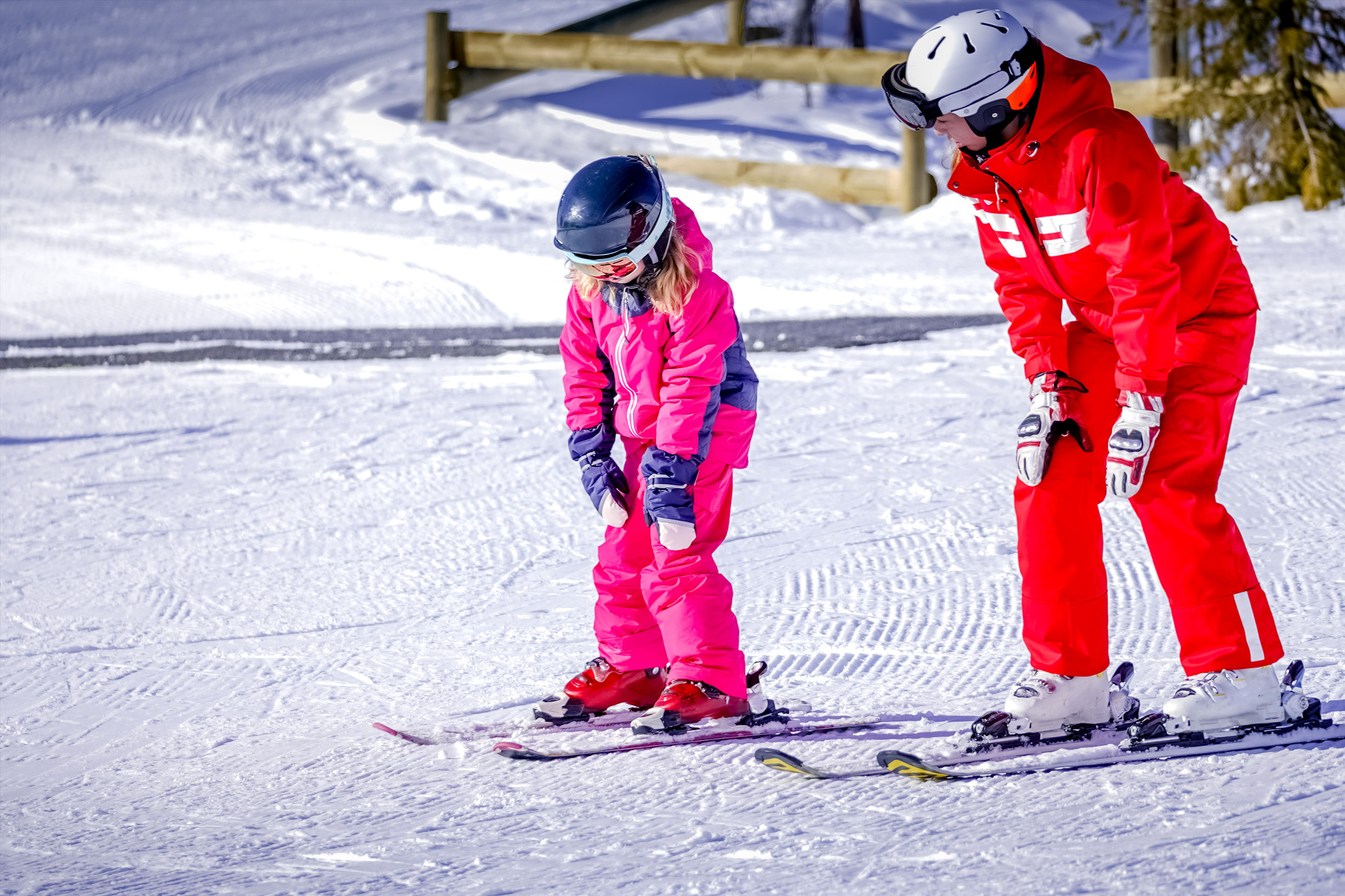 Woman teaching a young girl to ski.