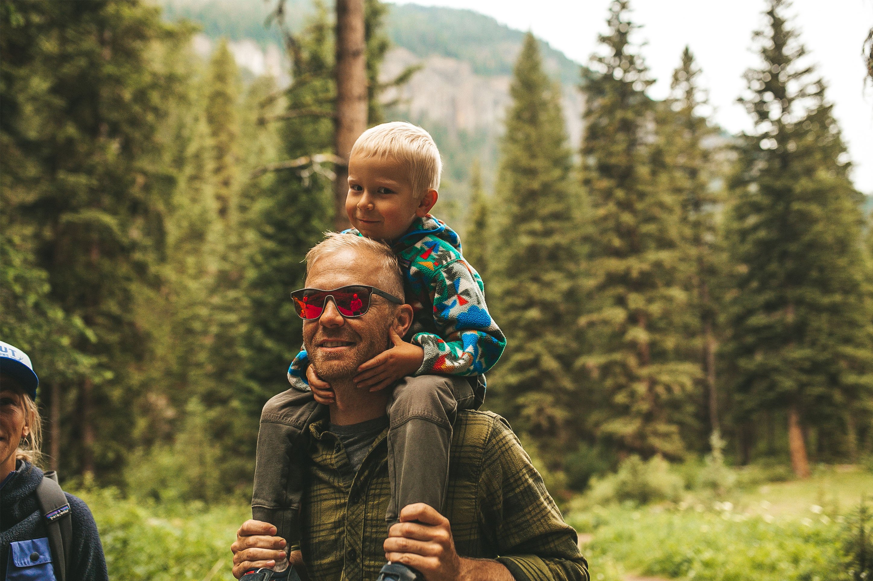 Photo of a man hiking with a child on his shoulders