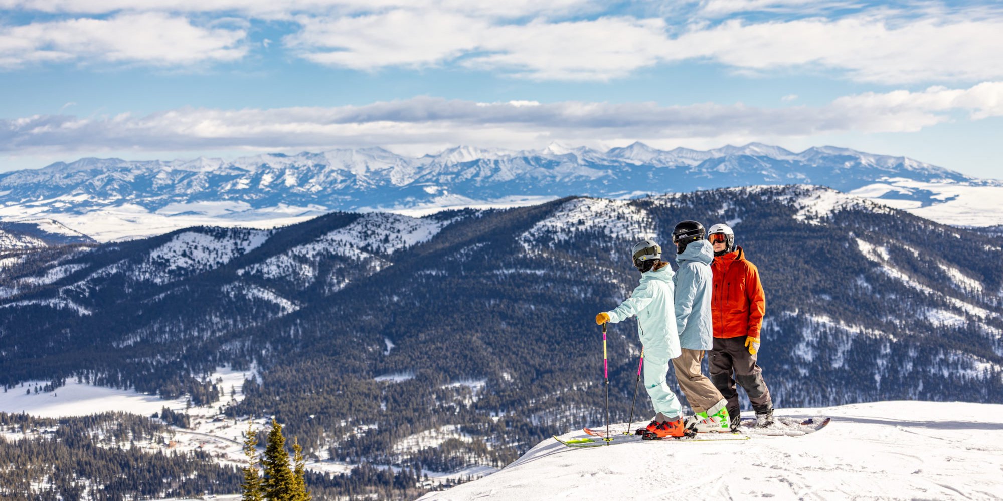 Three skiers at the top of a run at Bridger Bowl Ski Area.