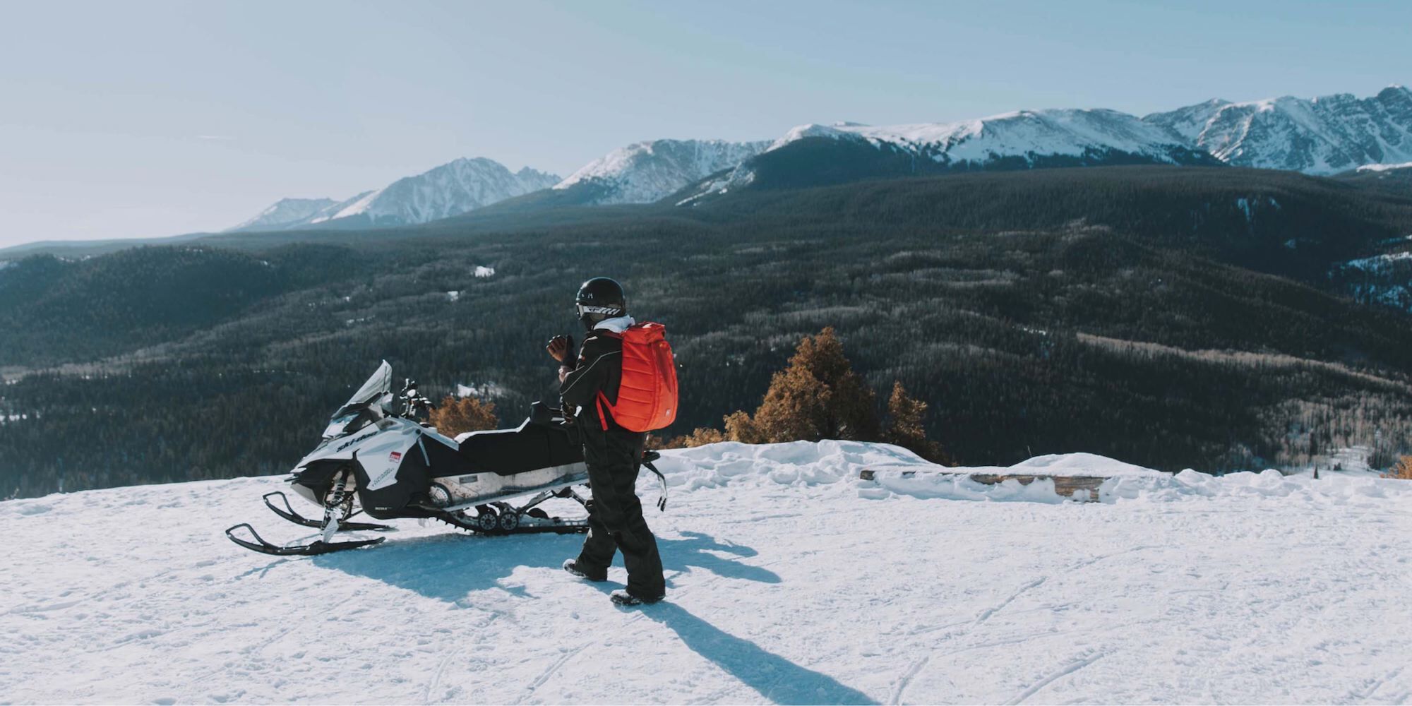 Snowmobiling in Bozeman, Montana with a scenic view of mountains.