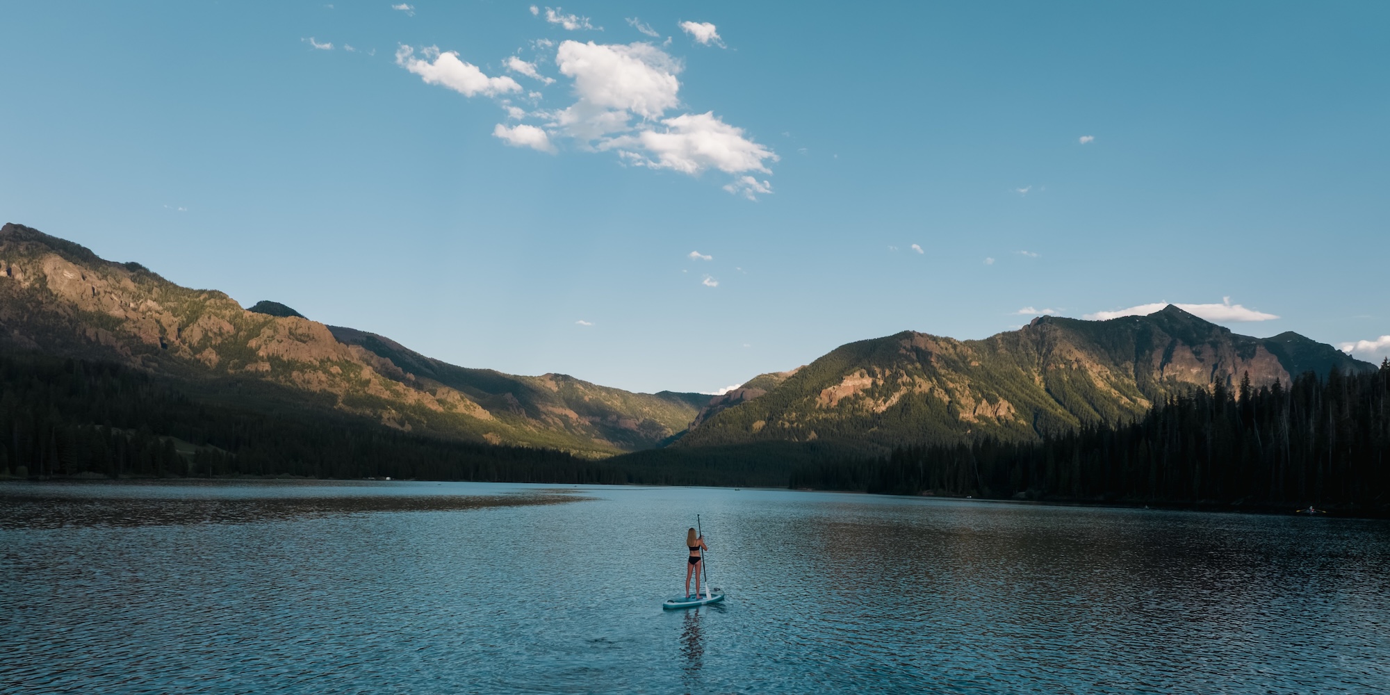 Woman stand up paddle boarding on Hyalite Reservoir.